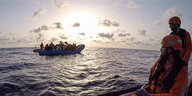 Die von der Seenotrettungsorganisation Sea-Eye herausgegebene Aufnahme zeigt Seenotretter vom Rettungsschiff «Alan Kurdi» die zu einem Schlauchboot voller Flüchtlinge schauen.