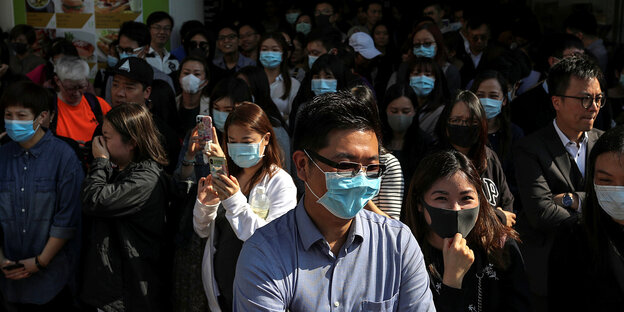 Menschenmenge in Hongkong, viele Menschen tragen einen Mundschutz