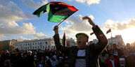 Ein Domonstrant schwenkt eine libysche Fahne