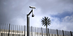 Eine Überwachungskamera ist am Zaun der Zentrale des Bundesnachrichtendienstes befestigt