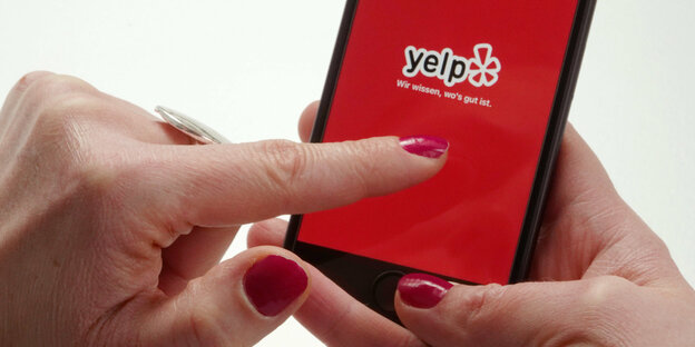 Die App der Bewertungsplattform Yelp wird von einer Nutzerin auf dem Smartphone geöffnet