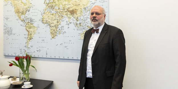 Der Leiter des Landesamtes für Einwanderung Engelhard Mazanke steht vor einer Weltkart.