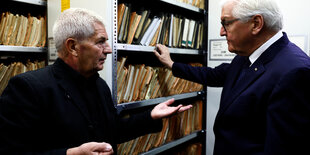 Bundespräsident Frank-Walter Steinmeier und der Bundesbeauftragte für die Stasi-Unterlagen Roland Jahn vor einem Aktenschrank.