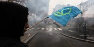 ein Mann schwenkt eine blaue Fahne mit dem Symbol der extinction rebellion-bewegung