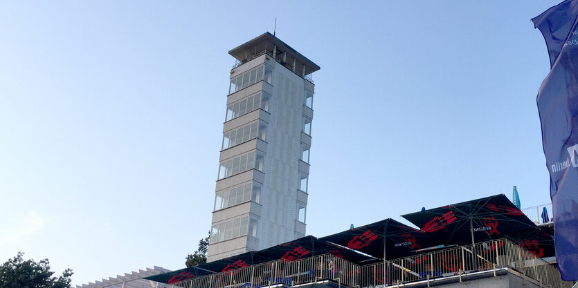 Das Bild zeigt den hohen, schmalen, weißen Müggelturm