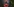 Eine Frau mit roter Plastikhose sitzt mit dem Rücken zurückgelehnt.