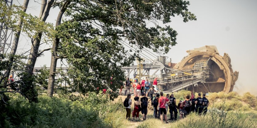 Menschengruppe vor einem Schaufelradbagger