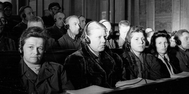 Frauen sitzen in einer Reihe mit Kopfhörern vor Gericht