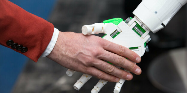 Roboter reicht Mensch die Hand