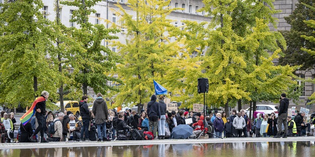 Das Foto zeigt junge Leute am Rande eines künstlichen Teiches. Sie gehören zur Fridays-for-Future-Bewegung, die für mehr Klimaschutz demonstriert.