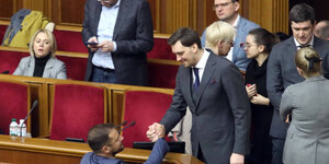 Alexej Gontscharuk schüttelt einem Abgeordneten im Parlament die Hand