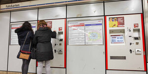 Frauen stehen vor einem Fahrkartenautomaten