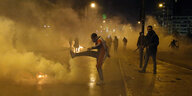 Vermummter Demonstrant in einer Tränengas-Schwade