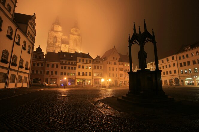 Die Stadtkirche in Wittenberg im abendlichen Nebel.