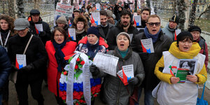 Protestierende mit einem Kranz in den russischen Farben