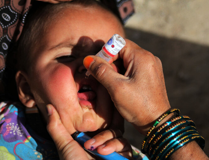 Ein Kind bekommt eine Schluckimpfung gegen Polio.