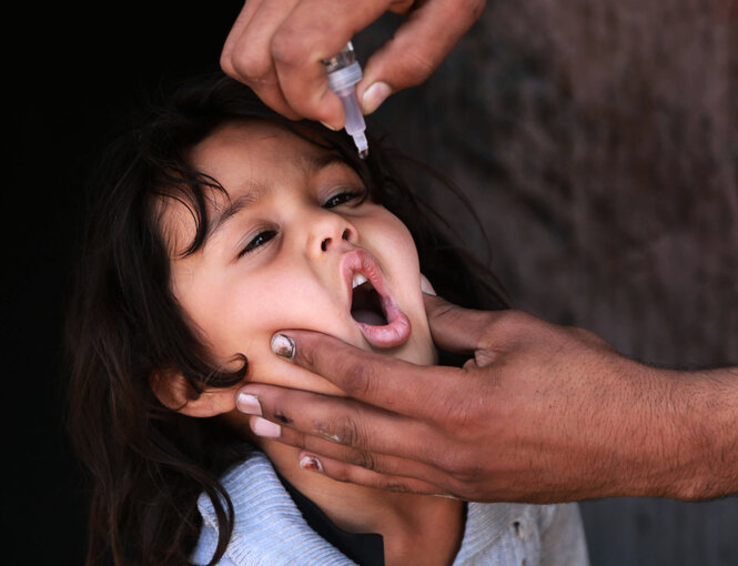 Ein Kind bekommt eine Schluckimpfung gegen Polio.