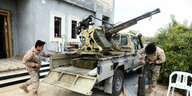 Kämper der Regierungstruppen in Libyen an eiinem Pickup mit Geschütz.