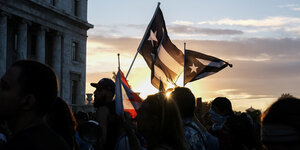 Menschen halten die Flagge Puerto Ricos in die Luft
