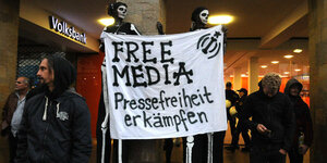 2 MÄnner im Totenkostüm halten ein Transparent "FreeMedia"