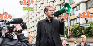 Kreuzbergs Baustadtrat Florian Schmidt spricht bei einem Mieterprotest in Kreuzberg in ein Megaphon