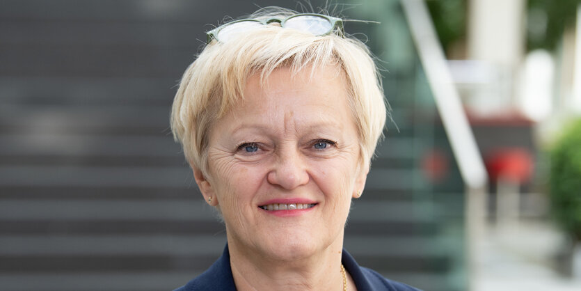 Blonde Frau lacht vor einer Treppe. Es ist Renate Künast