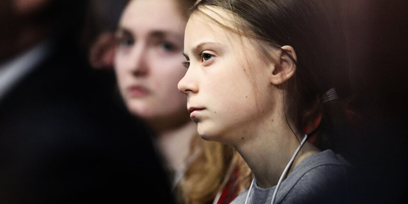 Die schwedische Klimaaktivistin Greta Thunbergwährend einer Rede im Publikum zwischen anderen Menschen.