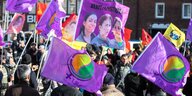 Menschen mit lila Fahnen auf einer Demonstration