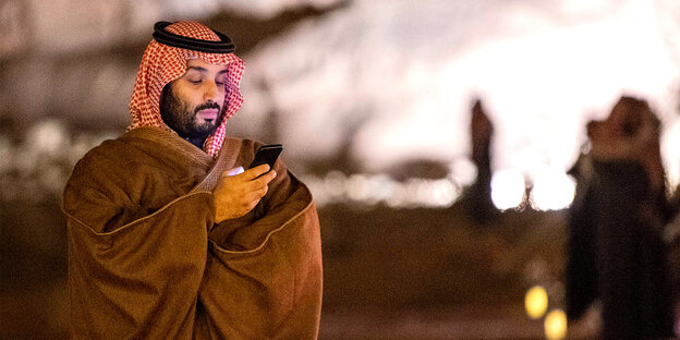 Mohammed bin Salman schaut auf sein Smartphone