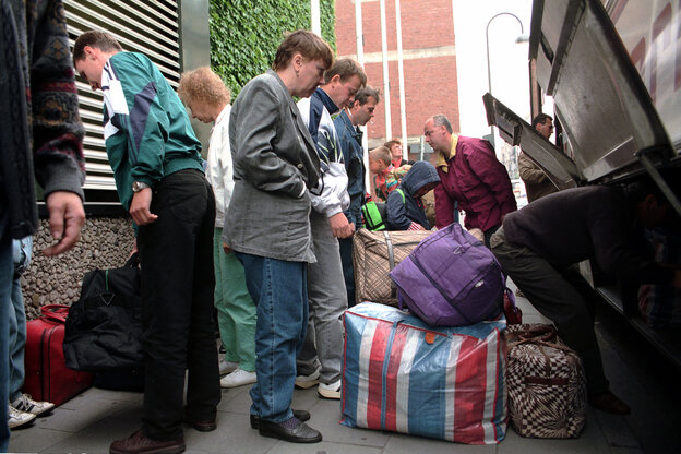 Menschen mit Gepäck an einem Reisebuss auf einem historischen Foto von 1996.