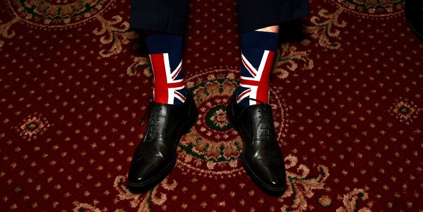 Ein Mann trägt Union Jack Socken, sie blitzen unter seiner Hose hervor