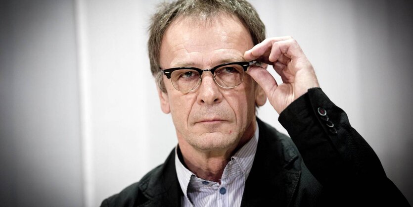 Josef Haslinger fasst sich bei einer Pressekonferenz an seine Brille.