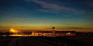 Das historische Eingangstor des Konzentrationslager Auschwitz-Birkenau unter einem großen Zeltdach.