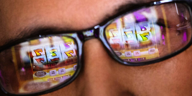 In Brillengläsern spiegelt sich eine Online Glücksspielseite.