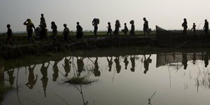 Flüchtlinge spiegeln sich in einem Gewässer