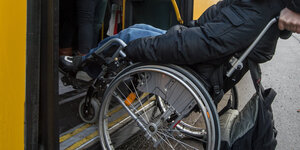 Ein Rollstuhl wird vor der Bustür angekippt um die Höhendifferenz zum Einstieg zu überwinden