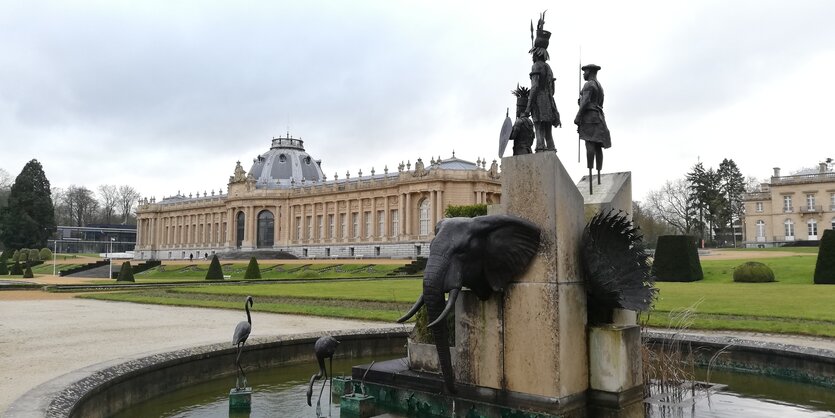 Blick auf einen Skulpturenbrunnen und Park, im Hintergrund ein altes und ein neues Museumsgebäude.