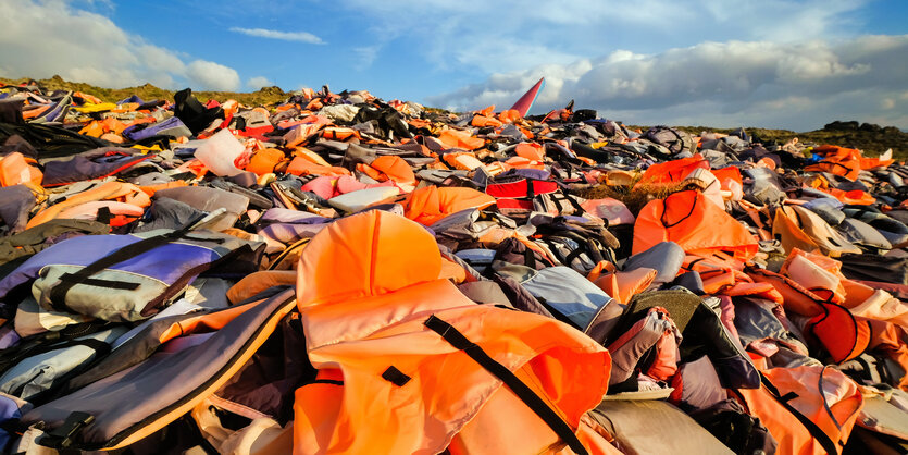 Ein mit orangenen Schwimmwesten übersähter Hügel