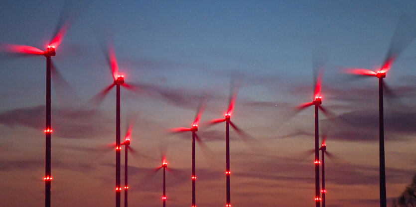 Windräder mit roten Positionslichtern vor Sonnenuntergang