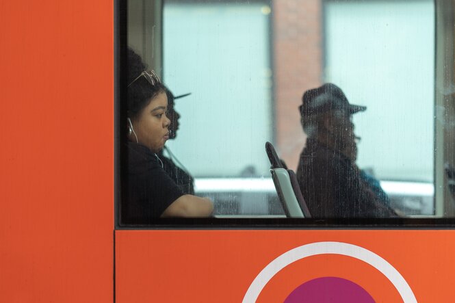 Passagierin in einem Bus trägt Köpfhörer