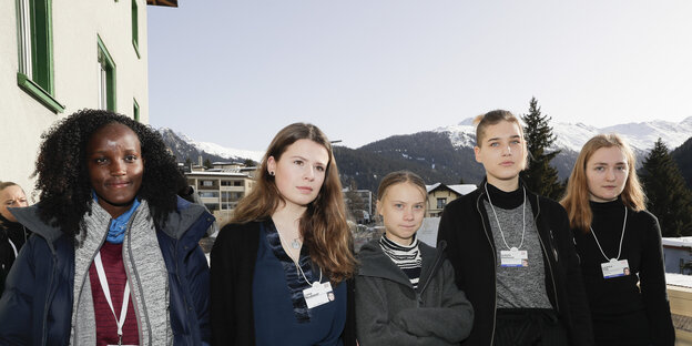 Fünf Frauen vor Bergen und blauem Himmel. Ganz links Vanessa Nakate, hinter ihr ein Haus.