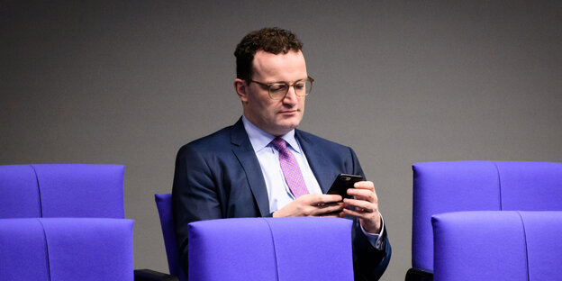 Bundesgesundheitsminister mit Smartphone im Bundestag.