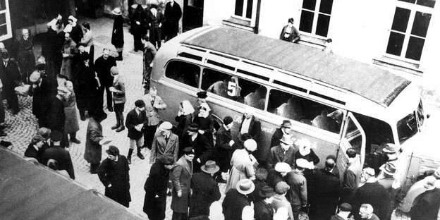 Historisches Bild aus der NS-Zeit: Menschen werden in Bussen abtransportiert.