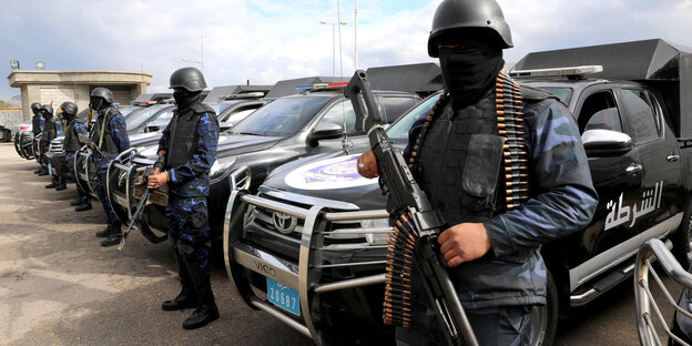 Vermummte Kämpfer der Regierung in Tripolis vor ihren Fahrzeugen.