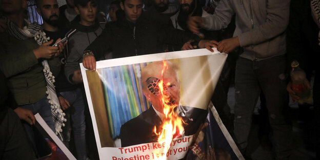 Ein brennendes Plakat mit dem Bild von US-Präsident Trump.