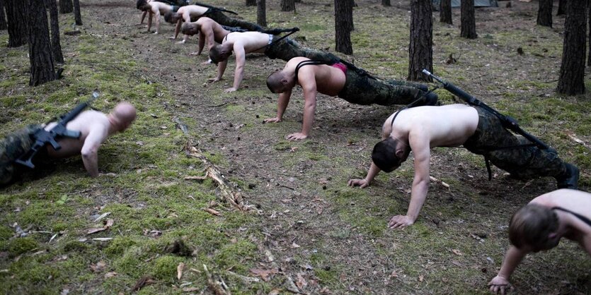 Bundeswehrsoldaten machen mit freiem Oberkörper Liegestützen.