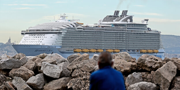 Ein Kreuzfahrtschiff mit rauchendem Schornstein im Hafen von Marseille.