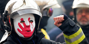 Ein französischer Feuerwehrmann demonstriert mit erhobener Faust.