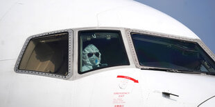 Ein Pilot mit Schutzanzug im Cockpit eines Flugzeugs.