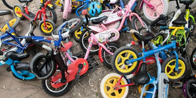 Viele Laufräder im Hof eines Kindergartens.